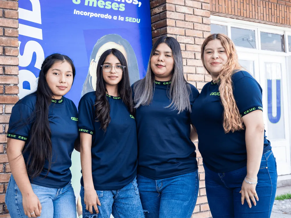 Estudiantes de CEUC con playeras de la escuela frente a su plantel