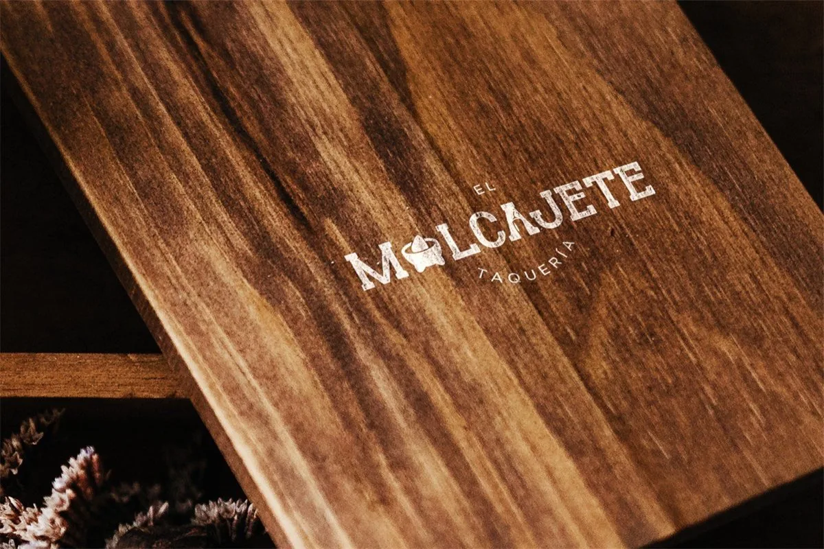 Logotipo de la taquería El Molcajete grabado en madera